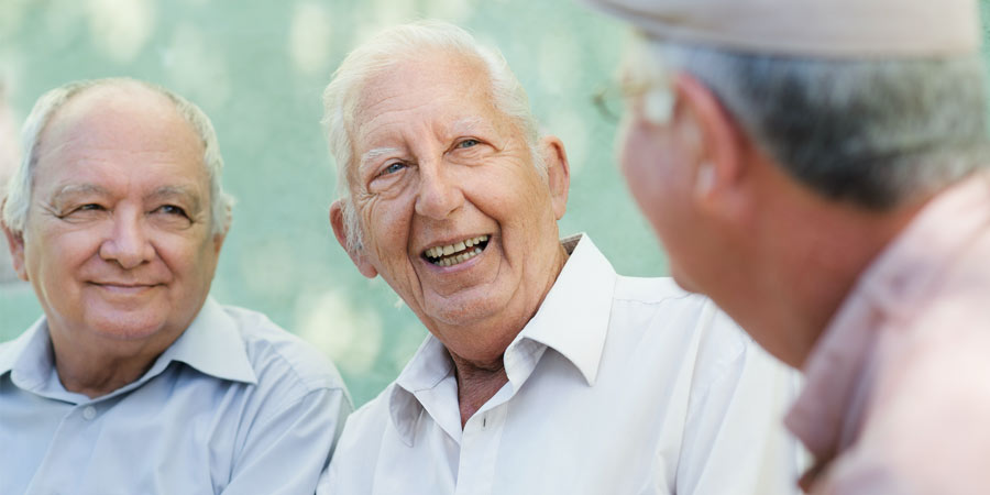 senior man with dementia talking with friends